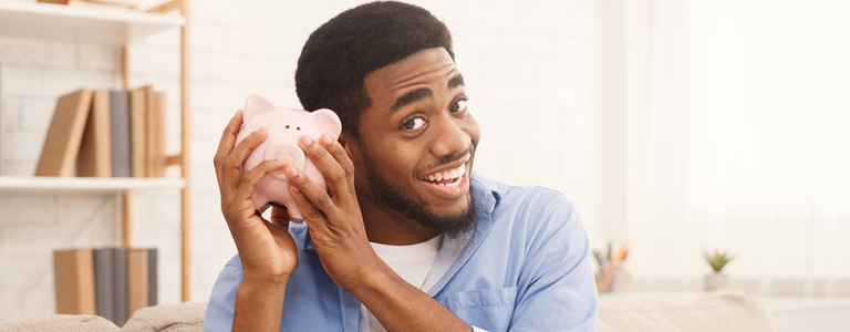 man holding piggy bank to ear